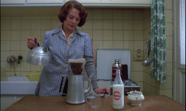 Jeanne (Delphine Seyrig) makes coffee.